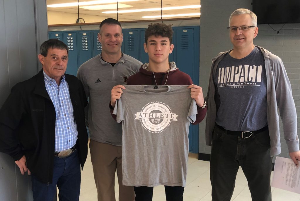 Winner of Impact Athlete of the Week, Ryan Allred, holding up his shirt, along with physical therapist, Michael Siegenthaler, and his two coaches.