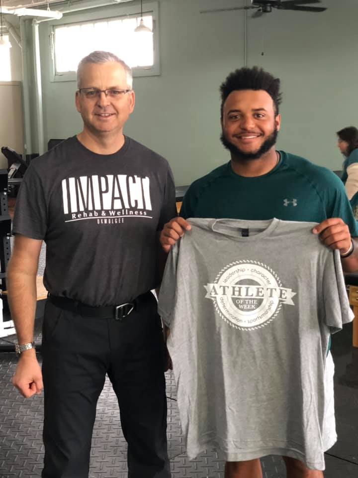 Winner of Impact Athlete of the Week, Jared Sutter, holds up his shirt with physical therapist, Michael Siegenthaler.