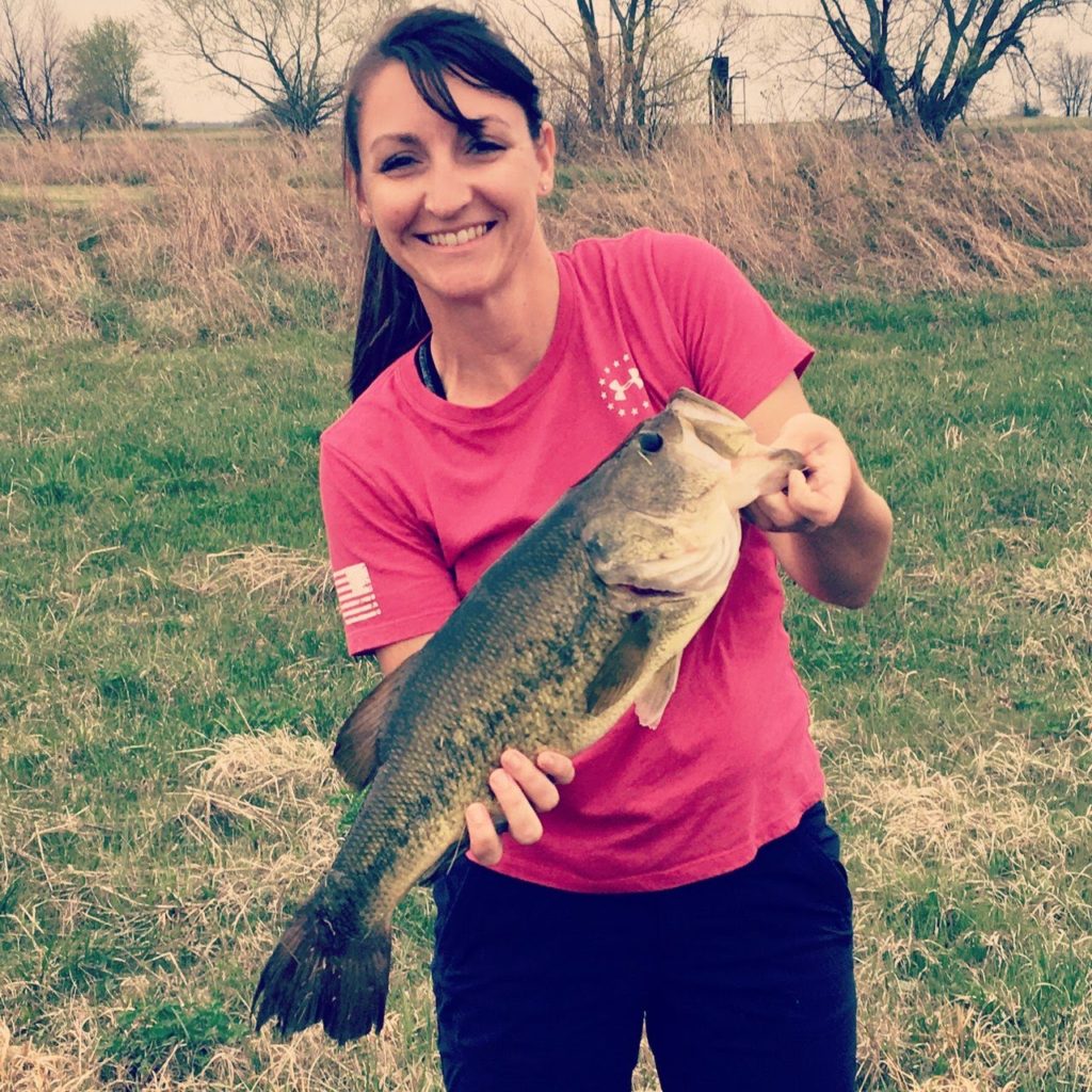 Michelle with the big bass she caught while fishing.